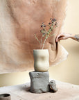 Une carafe de couleur beige moucheté de l'entreprise Dompierre est sur une table dans un décor terreux.
